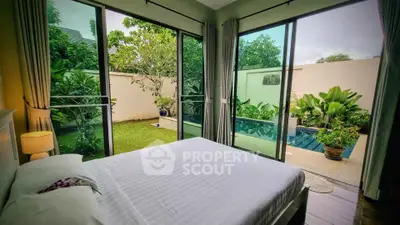 Luxurious bedroom with pool view and lush garden, perfect for relaxation.