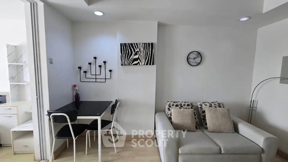 Modern living room with stylish decor and compact dining area in a cozy apartment.