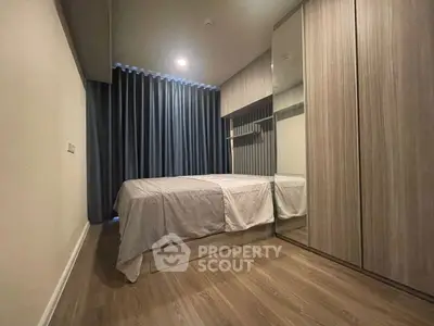 Cozy modern bedroom with wooden flooring and ample storage space