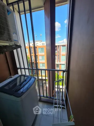 Compact balcony with washing machine and city view