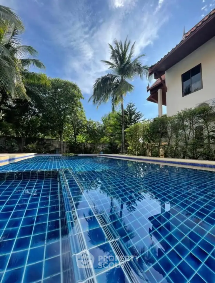 Luxurious outdoor pool with tropical landscaping and modern architecture, perfect for relaxation and leisure.