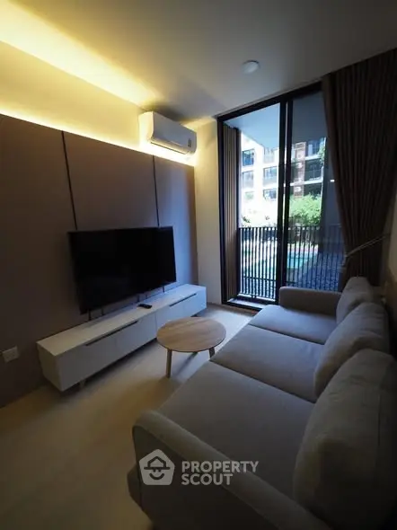 Modern living room with sleek furniture and large window overlooking a scenic view.