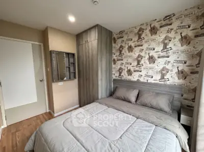 Cozy bedroom with stylish wallpaper and modern furnishings in a real estate property.