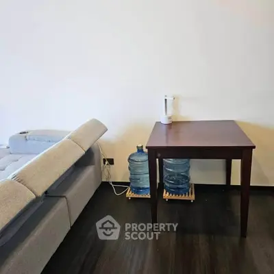 Modern living room with sleek furniture and water dispenser, perfect for a minimalist lifestyle.