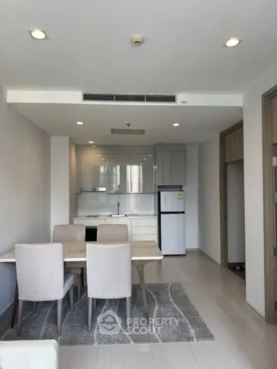 Modern open-layout kitchen and dining area with sleek design and neutral tones.
