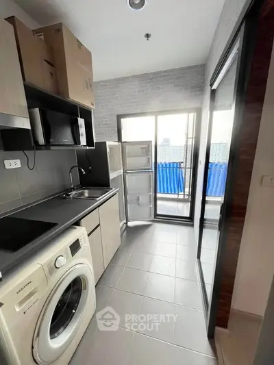 Modern kitchen with washing machine and balcony view in high-rise apartment