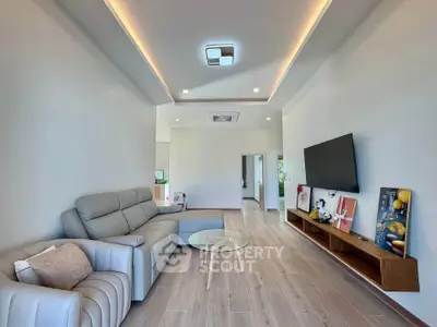 Modern living room with sleek furniture and wall-mounted TV, featuring elegant lighting and wooden flooring.