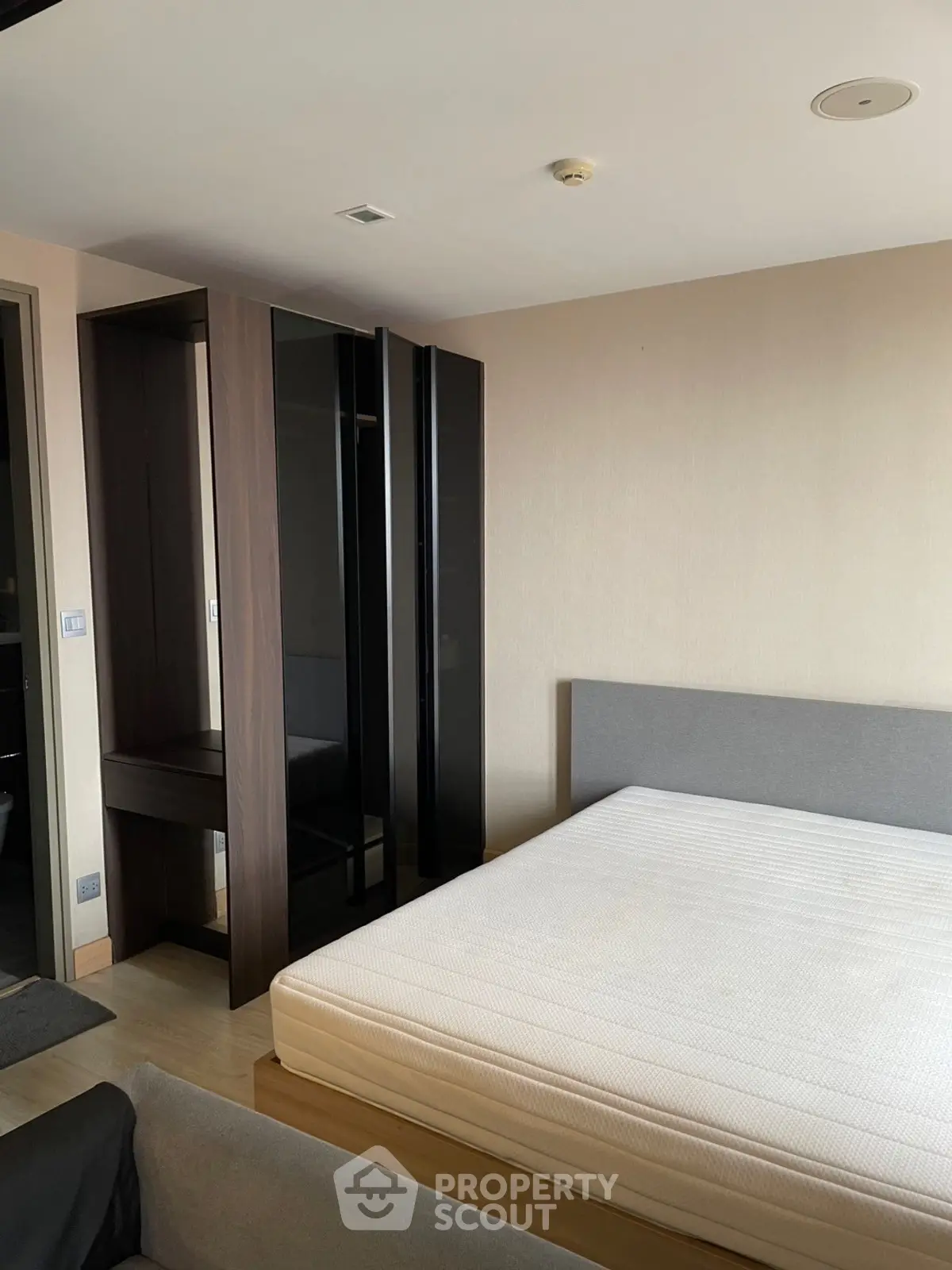 Modern bedroom with minimalist design featuring a sleek wardrobe and comfortable bed.