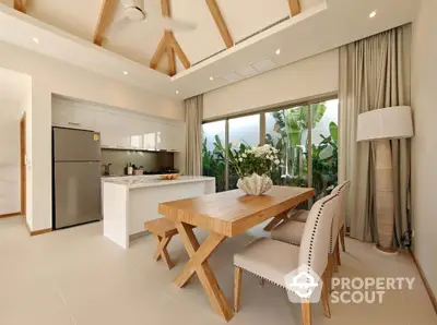 Modern kitchen with wooden dining set and large windows overlooking lush greenery