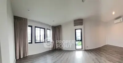 Spacious empty room with large windows and elegant curtains, perfect for customization.