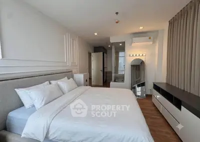 Spacious modern bedroom with elegant decor and ample natural light