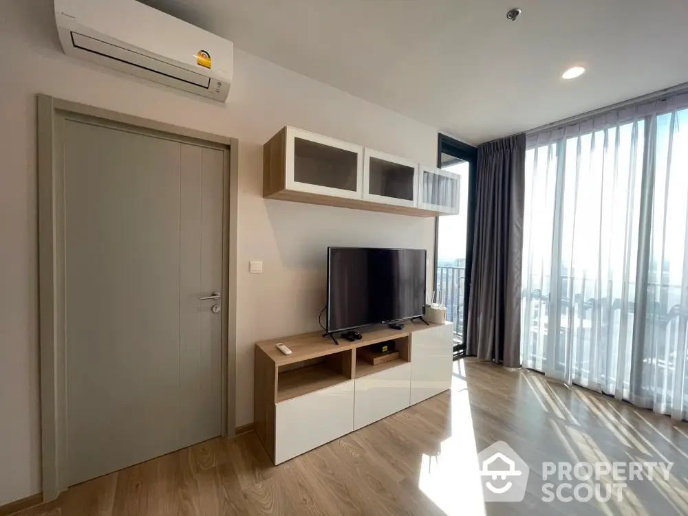 Modern living room with TV unit and large window offering city views