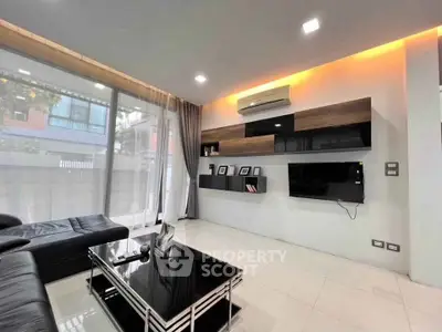 Modern living room with sleek furniture and large windows in a stylish apartment.