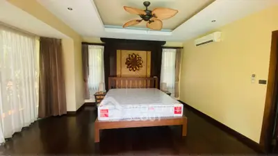 Spacious bedroom with elegant wooden flooring and large windows in a luxury home.