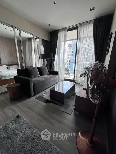 Modern living room with floor-to-ceiling windows and balcony view in a high-rise apartment.