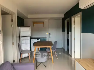 Modern apartment interior with dining area, washing machine, and air conditioning.