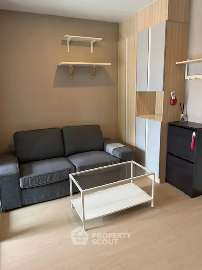 Modern living room with sleek sofa and minimalist decor in a cozy apartment setting.