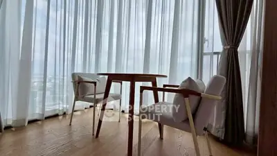 Bright corner unit with floor-to-ceiling windows and cozy seating area.