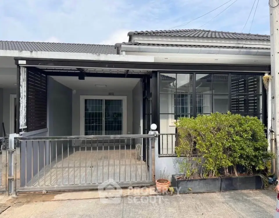 Charming single-story home with gated entrance and lush greenery