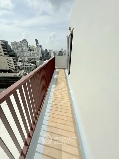 Spacious balcony with stunning city skyline view in modern high-rise building.