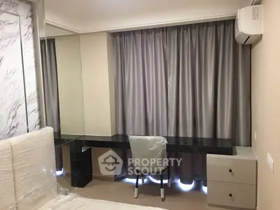 Modern bedroom with sleek desk and chair, featuring elegant curtains and air conditioning.