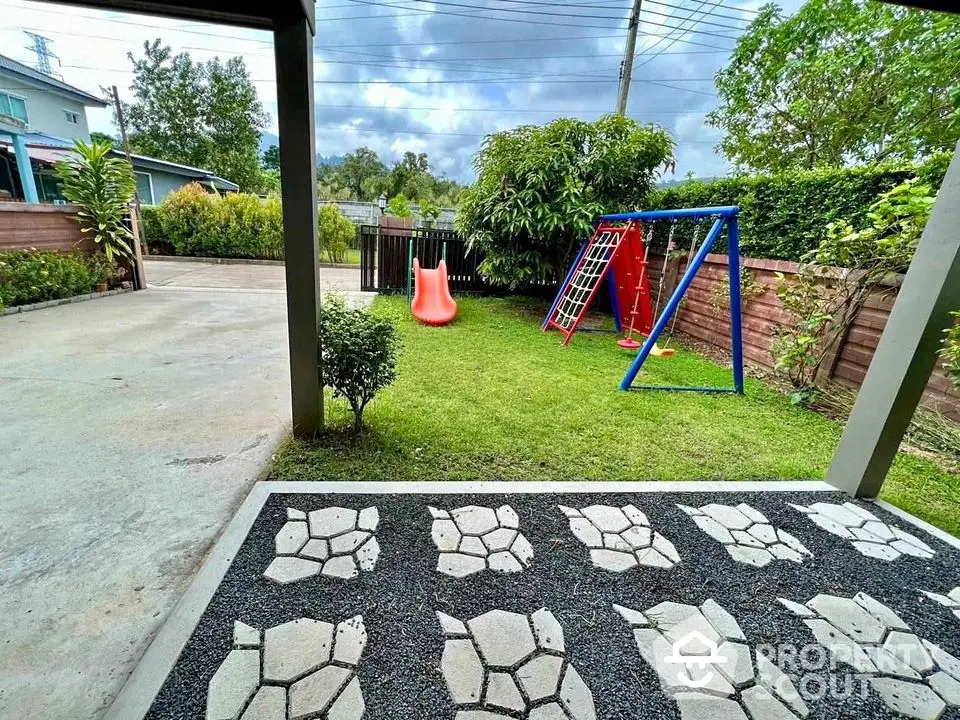 Charming backyard with playground set and lush greenery, perfect for family fun and relaxation.