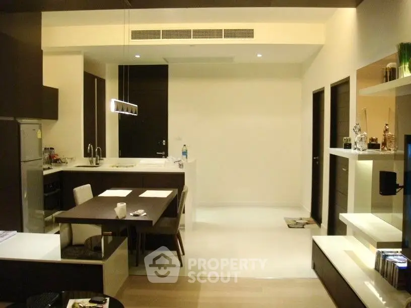 Modern open-layout kitchen and dining area with sleek design and ambient lighting.