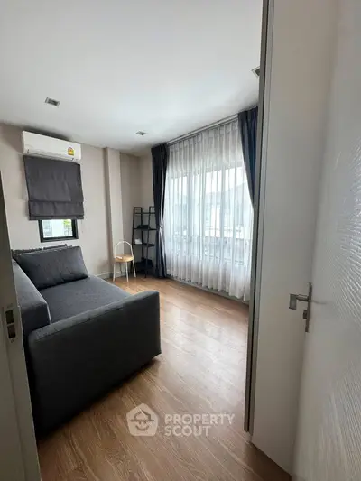 Modern living room with large window and stylish gray sofa