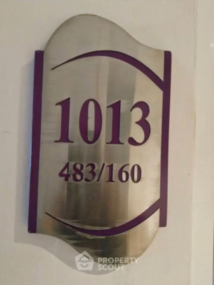 Stylish metallic room number plaque with modern design for property identification.