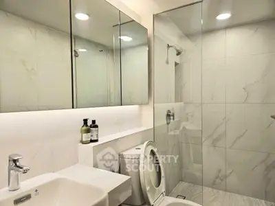 Modern bathroom with glass shower and sleek fixtures in luxury apartment