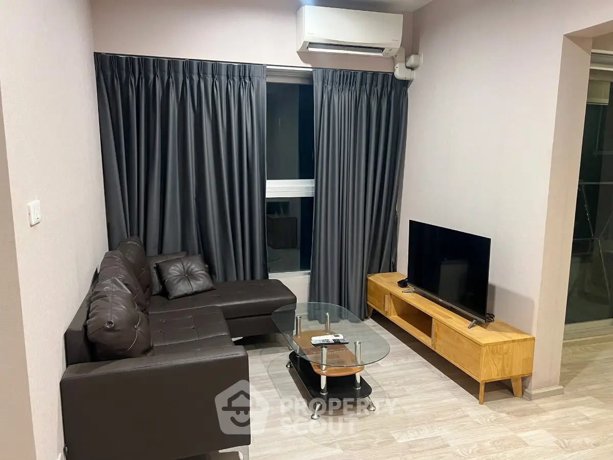 Modern living room with sleek furniture and stylish decor, featuring a cozy sectional sofa and flat-screen TV.