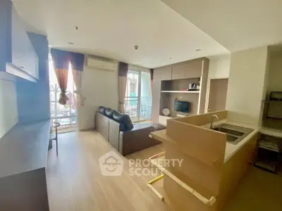 Modern open-plan living room with kitchen and balcony view in a stylish apartment.