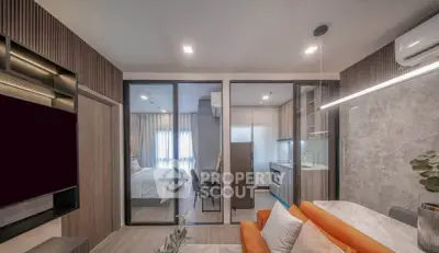 Modern open-plan living room with kitchen and bedroom, featuring sleek design and contemporary furnishings.