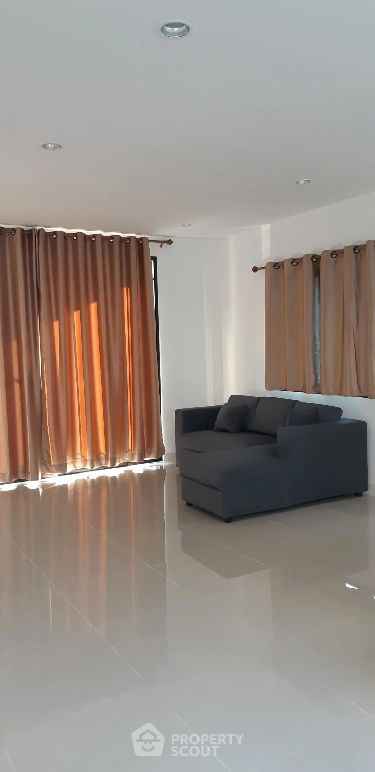 Spacious living room with modern sofa and floor-to-ceiling curtains