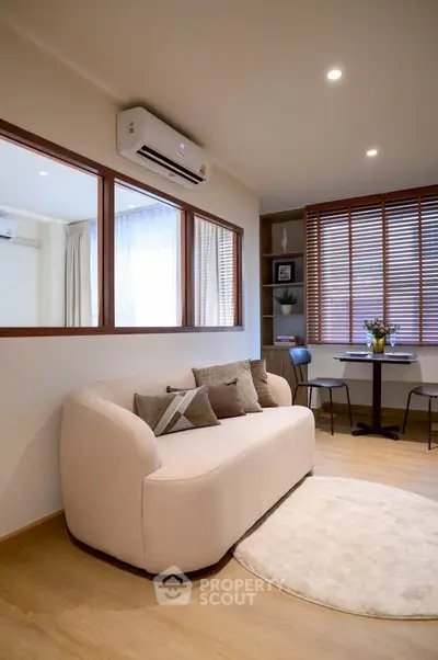 Modern living room with cozy sofa, air conditioning, and stylish decor in a bright apartment.