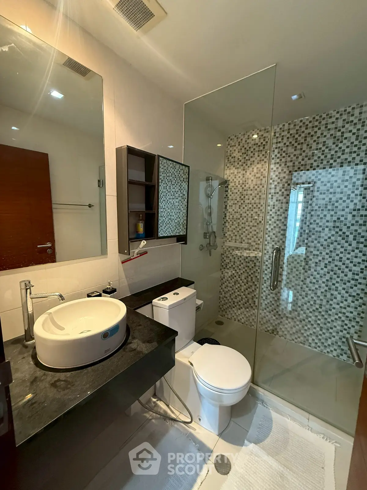 Modern bathroom with glass shower and stylish sink in a contemporary home.