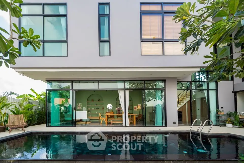 Modern luxury home with pool and glass facade, perfect for entertaining.