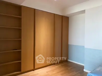 Spacious bedroom with built-in wooden wardrobe and shelving