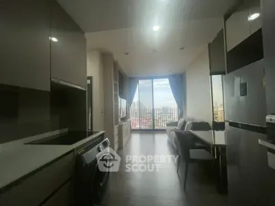 Modern apartment interior with open kitchen and city view, featuring sleek appliances and stylish decor.