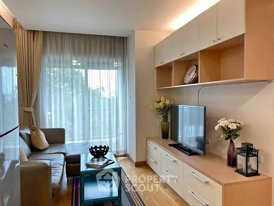 Modern living room with cozy sofa, large TV, and elegant decor in a bright apartment.