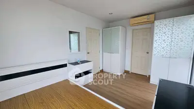 Spacious bedroom with modern furniture and wooden flooring