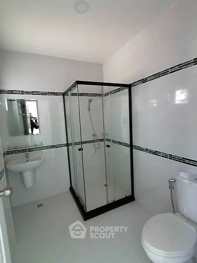 Modern bathroom with glass shower enclosure and sleek white fixtures