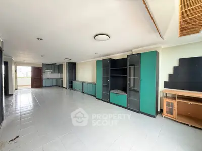Spacious living room with built-in cabinets and tiled flooring, ideal for modern living.