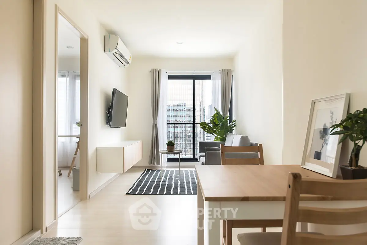 Modern living room with balcony view, stylish furniture, and natural light in a contemporary apartment.