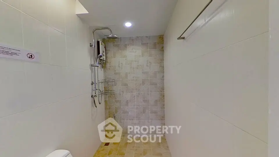 Modern bathroom with tiled shower area and sleek fixtures