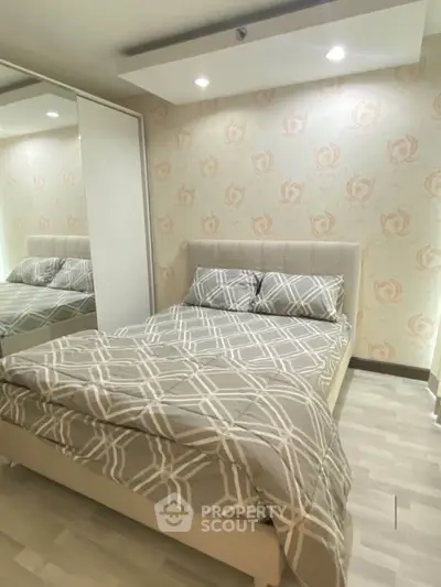 Cozy bedroom with modern decor and stylish wallpaper, perfect for relaxation.