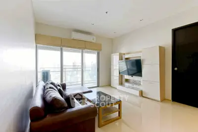 Modern living room with city view, sleek furniture, and large windows for natural light.