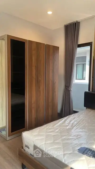 Modern bedroom with wooden wardrobe and large window for natural light