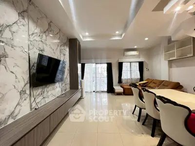 Modern living room with marble accent wall and stylish furniture