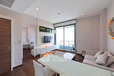 Modern living room with sleek furniture and balcony access in a stylish apartment.